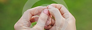 Broken nail on a woman`s hand with a manicure on a green background BANNER, LONG FORMAT