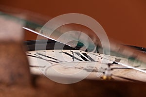 Broken old analog clock with glass and metal frame on wooden table, broken structure