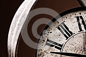 Broken old analog clock with glass and metal frame on wooden table, broken structure