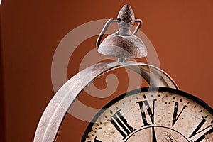 Broken old analog clock with glass and metal frame on wooden table, broken structure