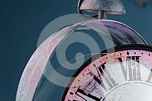 Broken old analog clock with glass and metal frame on wooden table, broken structure