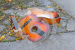 Broken old guitar lying on the concrete, discarded on a New York City street