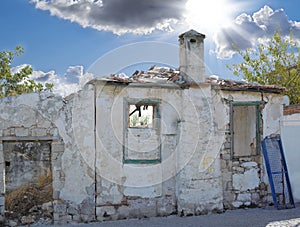 A broken old house abandoned from poverty, unemployment on city outskirts. Empty rustic dilapidated home in ruins from