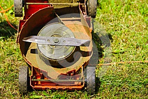 Broken old lawnmower in backyard grass