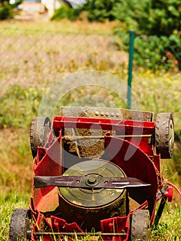 Broken old lawnmower in backyard grass