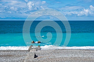 A broken old pier under the sea waves. blue sky and blue sea and coastline