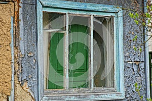 Broken old wooden window on the wall of the rural house