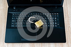 Broken padlock on open laptop computer. Internet and technology security breach