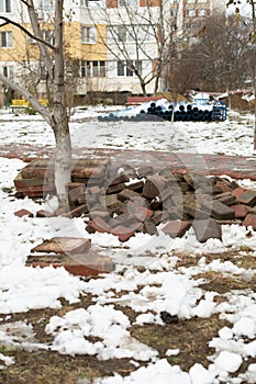 Broken paving slabs, metal fencing and protective construction tape