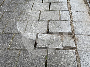 Broken paving slabs on sidewalk