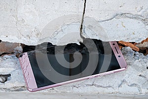 Broken phone between concrete blocks