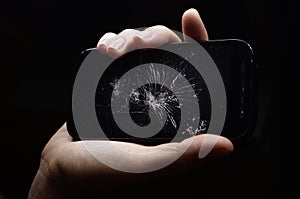 broken phone in hand on dark background, crash phone, fractured, smartphone repair
