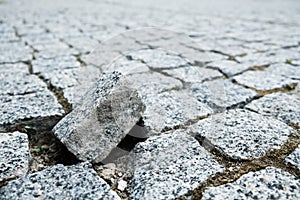 Broken piece of cobblestone street in an old medieval city. Paved boulevard made of stones. Urban footpath mosaic from rock