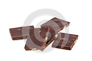 broken pieces of dark chocolate with nuts in a heap isolated on white background