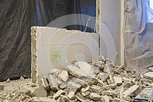 Broken pieces of wall lie near the wall being dismantled