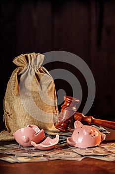 Broken piggy bank with money bag and judge gavel. Investment and bankruptcy concept. Vertical image