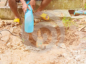 Broken pipe in hole with water motion at roadside and plumber working repair