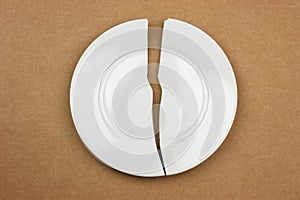 Broken plate on cardboard background