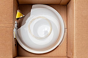 Broken plate in a cardboard box