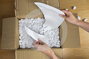 Broken plate in damaged cardboard box top view, damaged home delivery unpacking box