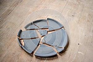 broken plate lying on a wooden table