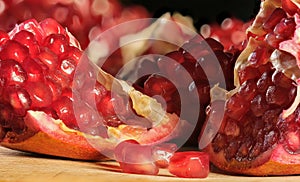 broken pomegranate with red ripe juicy kernels close-up