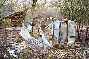 Broken primitive plastic greenhouse in farm garden