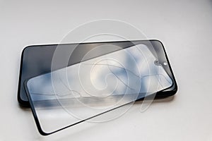 Broken protective shield on a black smartphone shows display protection and shatterproof transparent device protectors for crashs