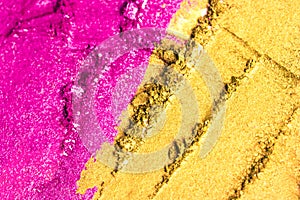 A broken purple and golden eye shadow make up palette isolated on a white background.