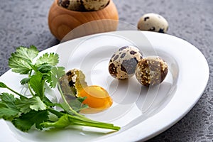 Broken quail eggs with parsley on the white table