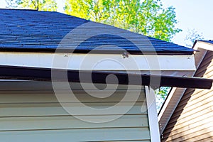 Broken rain gutter on roof of a house after hurricane damages