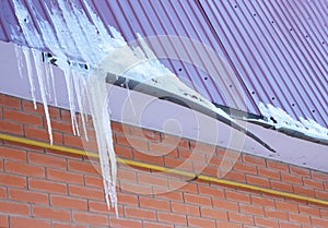 Broken Rain Gutters. Ice dam. Closeup on new broken rain gutter system without roof protection Snow guard on house construction.