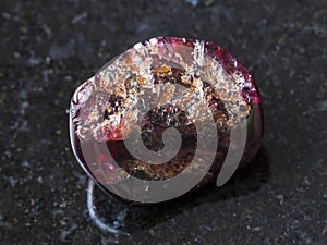 broken red garnet gemstone on dark background