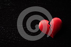 Broken red heart on black wooden background. Heart broken, Love and Valentines day concept