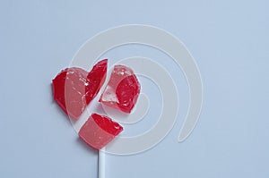 A broken red heart lollipop symbolizing a broken heart