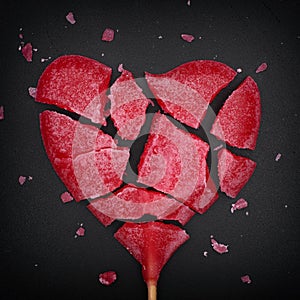 Broken red heart shaped lollipop