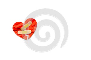 Broken red heart symbol with medical patch on white background, love concept. healing