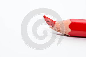 Broken red pencil on focus close up macro shot isolated on white background