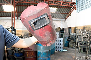 Broken Red welding mask in the man hand