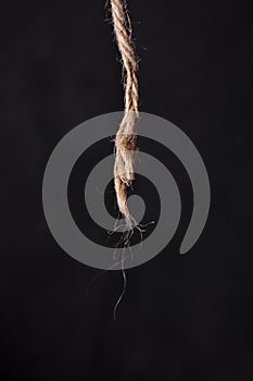 Broken rope on black background