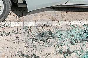 Broken and shattered window or windshield glass on the ground from damaged car