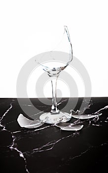 Broken shattered wine glass on marble background