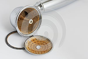 Broken shower head with limescale and rust on it.