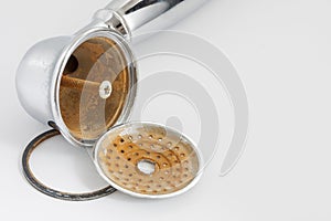 Broken shower head with limescale and rust on it.