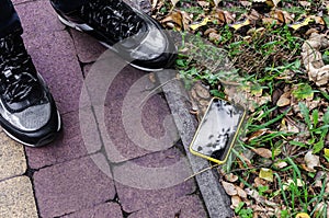 Broken smartphone on a paved road