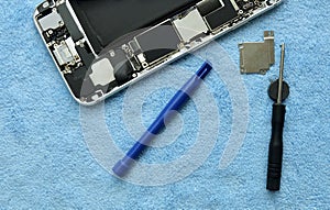 Broken Smartphone with Repair Equipment on Table