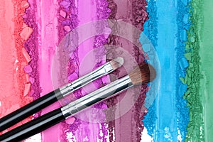 Broken and smashed color make-up eyeshadow palette, lay of brush strokes with brushes, close-up for background, top view