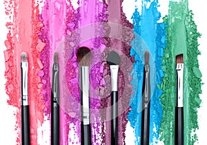 Broken and smashed color make-up eyeshadow palette, lay of brush strokes with brushes, close-up for background, top view