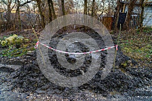 Broken soil fenced with branches and tape after the repair of communications. Background with copy space