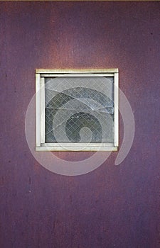 Broken Square Window in a Purple Metal Door